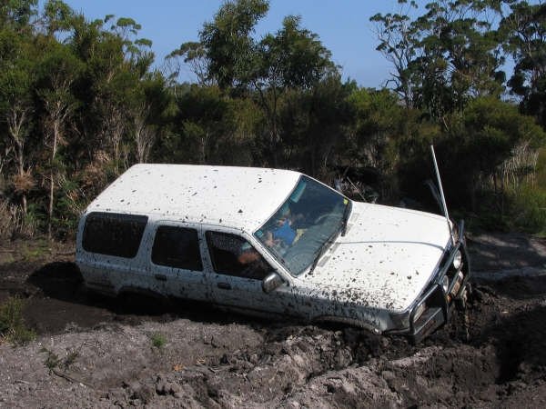 Paul in his four-wheel drive, bogged in the mud in the Tasmanian bush